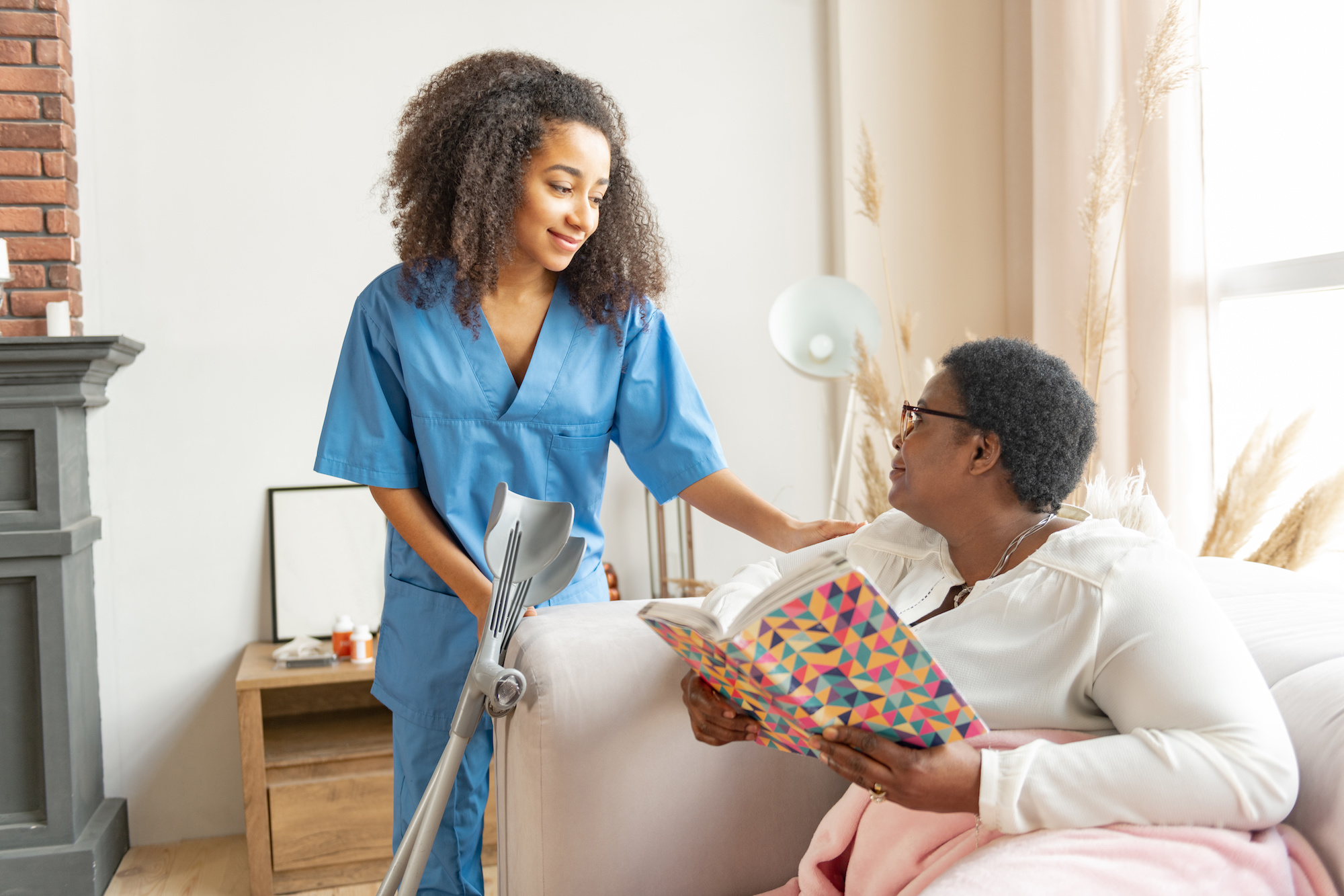 An in-home care aide comforting an elderly patient.