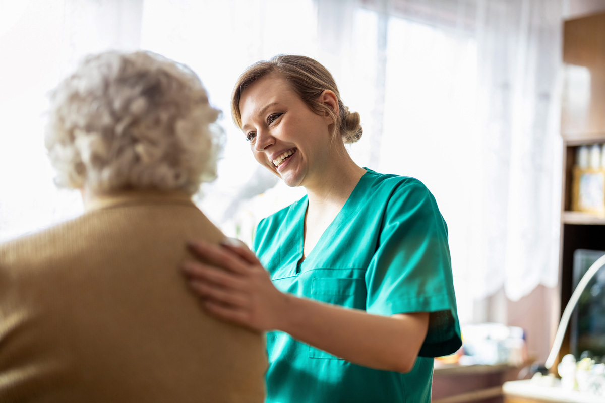 An in-home care nurse smiling at an elderly person in El Paso.